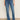 Someone wearing Sanctuary Clothing's Sculpted Hayden Bootcut Lucky Streak jeans stands against a light wall, pairing the high-waisted denim with beige pointed-toe shoes.