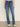 Someone wearing Sanctuary Clothing's Sculpted Hayden Bootcut Lucky Streak jeans stands against a light wall, pairing the high-waisted denim with beige pointed-toe shoes.