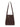 The belted tote mud bath by Sanctuary Clothing is a dark brown leather shoulder bag with an adjustable strap, gold-tone buckle detail on the front, and a clean, structured design.