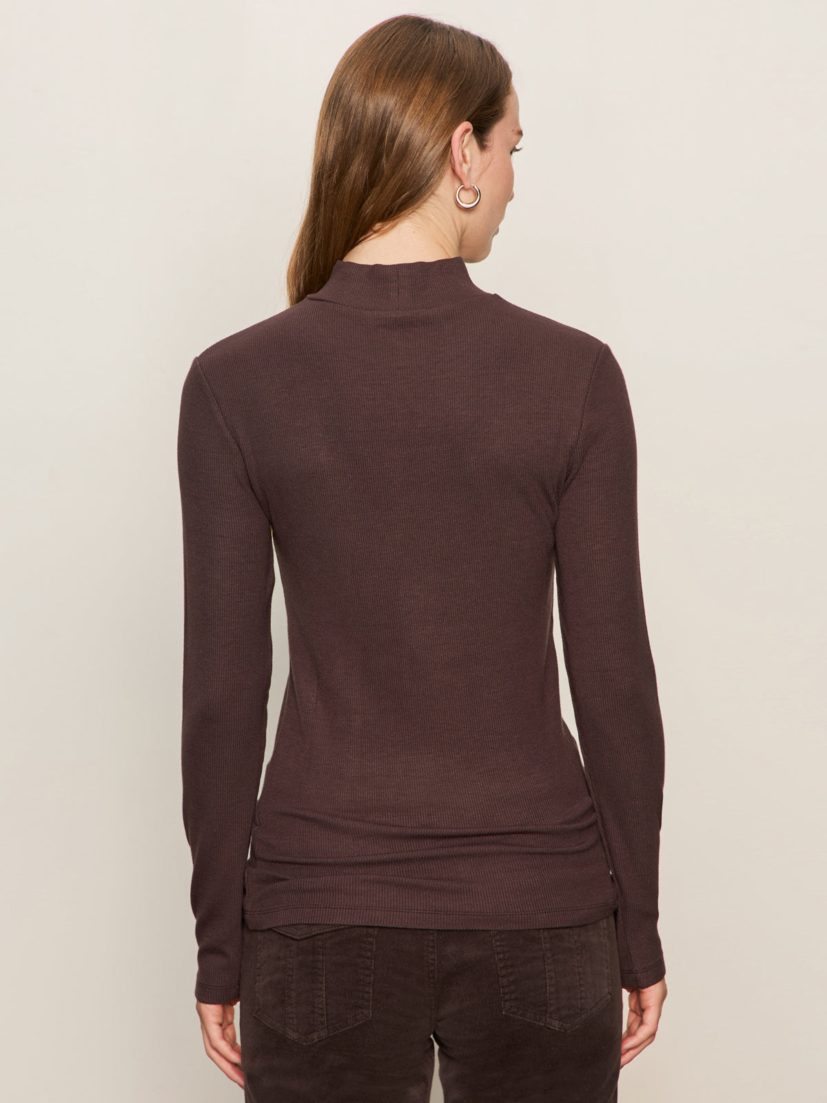 A person with long brown hair is shown from the back against a plain light background, wearing Sanctuary Clothingžs ls mock essential top semi sweet and matching pants.
