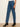 Blue jeans worn by a person on a plain background