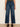 Person wearing blue jeans on a plain background
