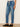 Person wearing blue jeans with a drawstring on a plain background