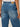 Blue jeans with a brand label on a neutral background