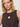 A blonde woman models Sanctuary Clothing’s "the desired summer crop shell rhythmic" dress, featuring a sleeveless patterned design and a large seashell pendant necklace, set against a plain light background.