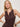 A woman with blonde hair models the Sanctuary Clothing breakaway mix media midi dress in rich soil, standing against a plain light background with one hand on her hip, styled with hoop earrings and chunky bracelets.