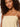 A person with curly brown hair wears the Sanctuary Clothing hideaway linen tie strap dress in banana, facing the camera with a neutral expression.