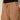 A person wears Sanctuary Clothing’s springtide short in toasted coconut—a high-waisted, relaxed fit short with visible stitching, side pockets, and a drawstring—paired with a black top and one hand in the pocket.