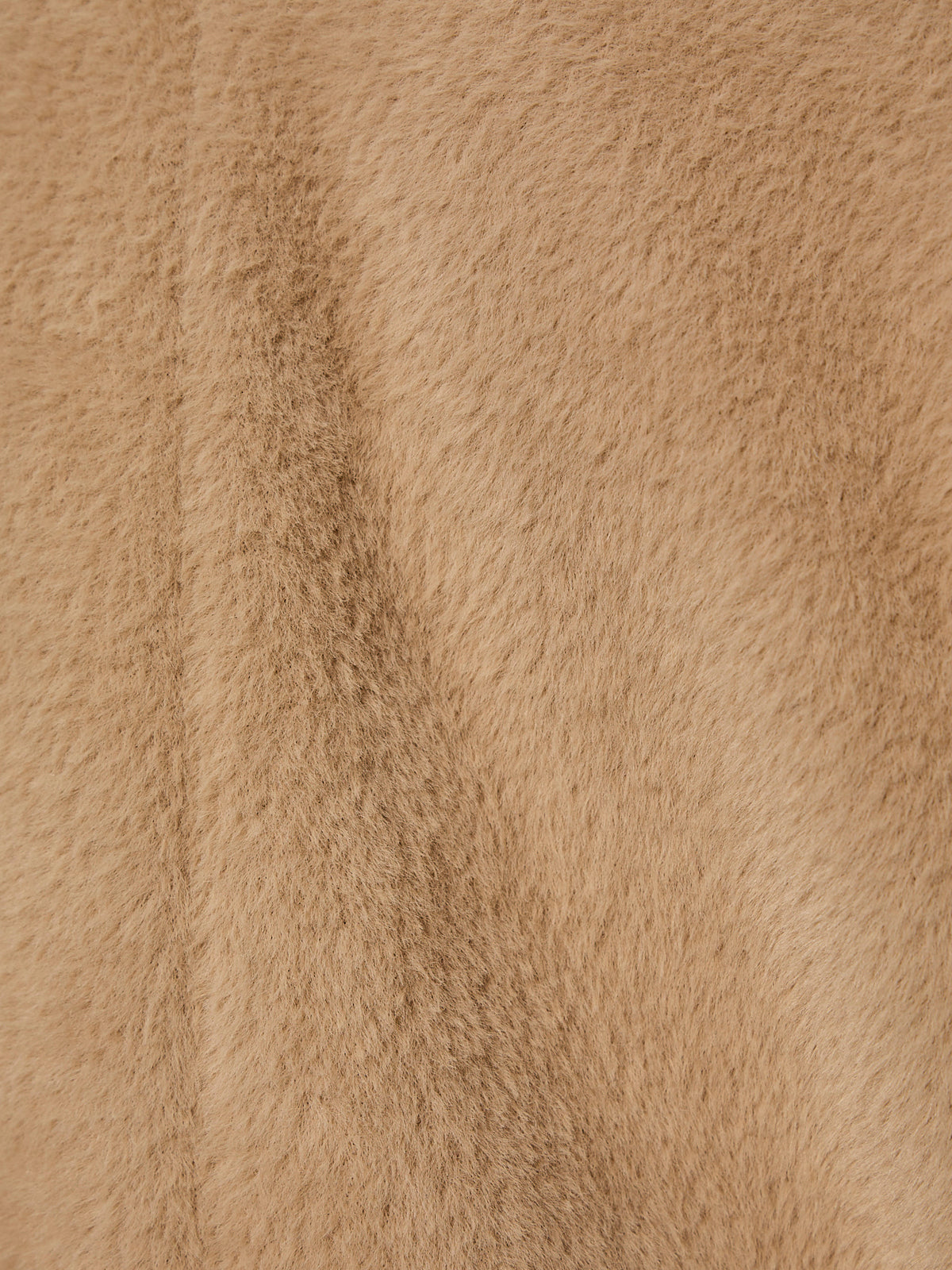 Close-up of the live in fur coat warm camel by Sanctuary Clothing, showing its soft, light brown faux-fur texture with fine short fibers and a subtle vertical seam.