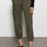 A person models the Sanctuary Clothing rebel pant hiker green cargo joggers, featuring side pockets, paired with black flat shoes; photo shows only the lower half of their body against a plain background.