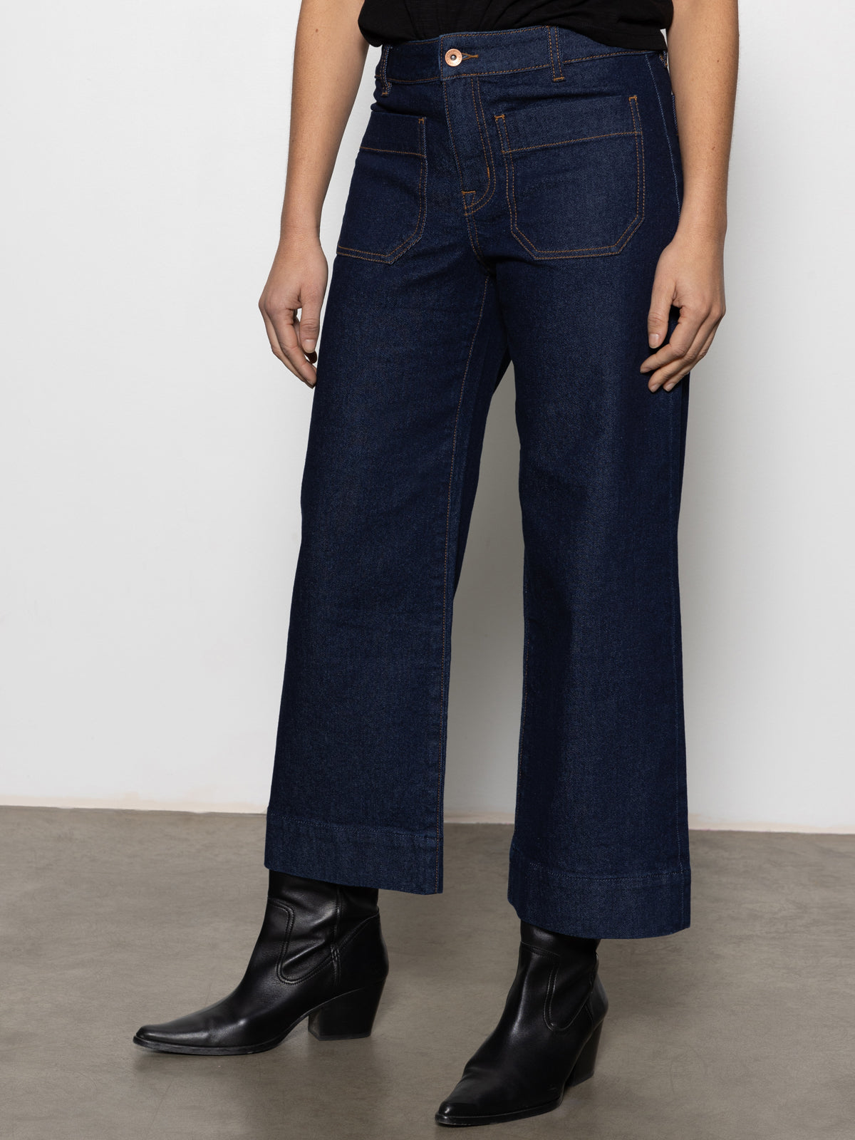 Wearing Sanctuary Clothing's "the marine magnetic" dark blue wide-leg jeans, the person stands on a concrete floor against a plain white wall, with the image highlighting the lower half of their body.