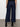 A person faces away, modeling Sanctuary Clothing's "the marine magnetic" dark blue wide-leg jeans with visible back pockets and black ankle boots, shown waist down against a plain background.