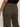 Someone wearing the Sanctuary Clothing marine crop trouser pant fatigue in olive green, a high-waisted style with back pockets, paired with a black top, shown from the waist down and viewed from behind.