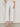 Wearing Sanctuary Clothing's The Marine Crop Jean in Chalk (petite sizing), a person pairs the white, wide-leg, ankle-length jeans with a cream sweater and nude heeled sandals against a light background.