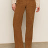 Someone wearing Sanctuary Clothing's corduroy marine pant in bronze, paired with a light beige long-sleeve top and cream heeled boots, stands against a plain background.