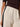 A person wears Sanctuary Clothing's casual track pant in summer sand with a black side stripe, paired with a dark brown ribbed short-sleeve top. The image is cropped to display the waist and upper legs.