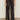 Someone wearing the Sanctuary Clothing modern satin trouser in black, styled with black pointed-toe shoes, stands against a light-colored wall on a neutral floor.