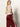 A woman with long blonde hair models the Sanctuary Clothing satin track pant in crimson, featuring white side stripes, paired with a shiny beige short-sleeve top. She stands against a plain light background, looking over her shoulder.