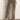 A person wears the Sanctuary Clothing cadence relaxed straight jean in light bronze with light-colored heeled shoes, standing against a plain light wall. Only the lower body is visible.