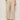 Someone wearing the Sanctuary Clothing lily stripe cropped pant in lido stripe (petite sizing) with a drawstring waist and wide legs, paired with beige sandals, stands against a plain background. One hand is in their pocket.