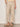 Someone wearing the Sanctuary Clothing lily stripe cropped pant in lido stripe (petite sizing) with a drawstring waist and wide legs, paired with beige sandals, stands against a plain background. One hand is in their pocket.