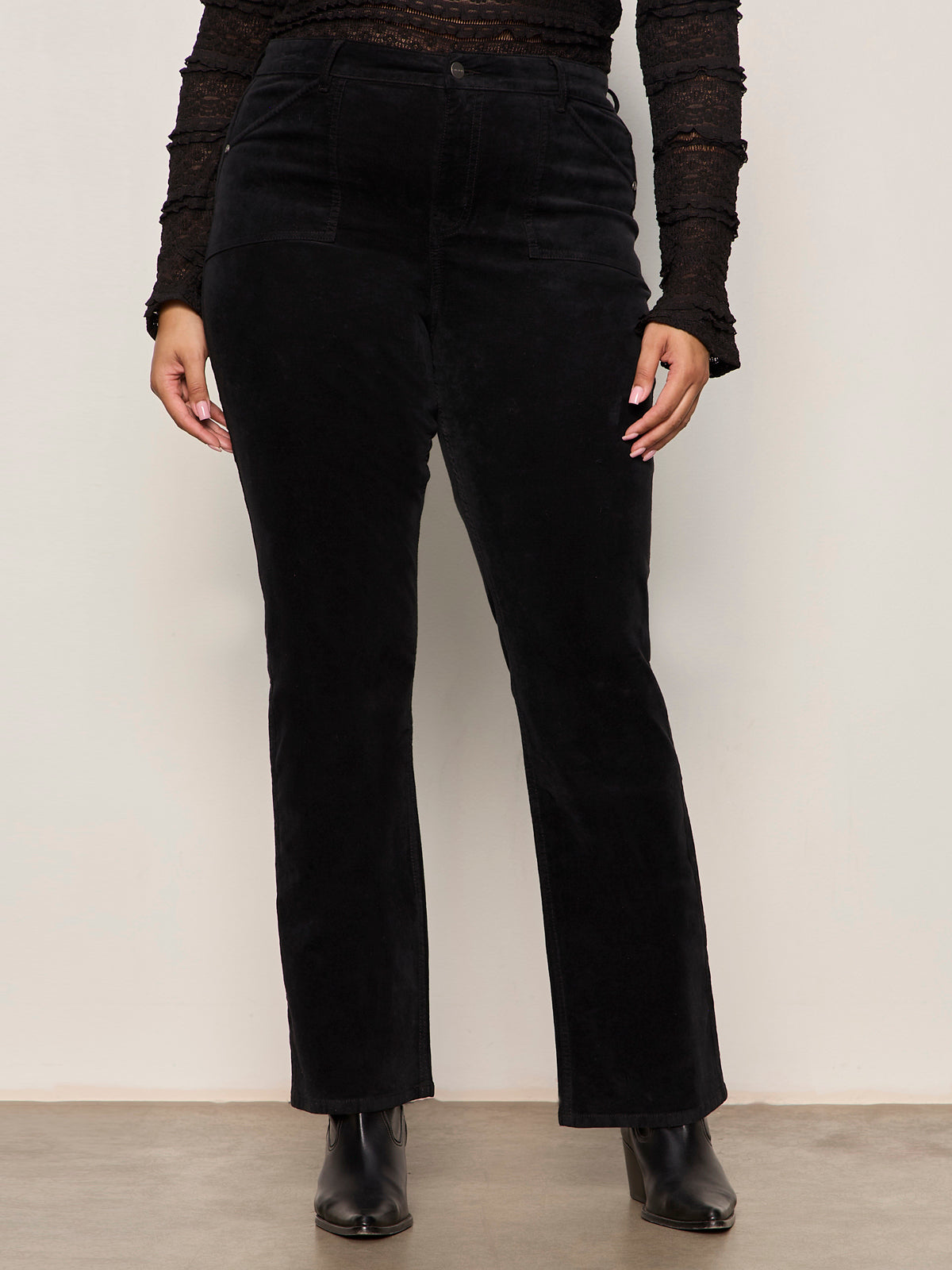 Person wearing black pants and a black top against a white background