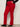 Person wearing red pants and black shoes on a plain background