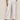 Wearing Sanctuary Clothing's "angels cargo pant white" with pockets and button details, styled with light brown heeled sandals and a pale yellow knit top. The image is cropped to show only the lower torso and legs.