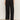A person wears the Sanctuary Clothing scout linen barrel pant in black with a white tucked-in top and black open-toe flat sandals, standing against a plain light background. Their head is not visible in the image.