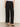 A person wears the Sanctuary Clothing scout linen barrel pant in black with a white tucked-in top and black open-toe flat sandals, standing against a plain light background. Their head is not visible in the image.