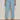 A person wears Sanctuary Clothing "retreat crop jean skyline" in petite sizing—light blue, high-waisted, wide-leg jeans with front patch pockets. Only their lower torso and legs are visible against a plain background.