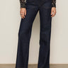Wearing Sanctuary Clothing's marine full length jean first sight, styled with a black floral long-sleeve top and black low-heeled shoes. The individual stands against a plain light background; image cropped below the shoulders.