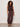 A woman with curly hair wears the Sanctuary Clothing "melody micro linen balloon rich soil" set— a sleeveless brown top and matching drawstring pants with elastic ankles—paired with flat sandals, standing on a gray floor against a plain wall.