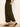 A person wearing Sanctuary Clothing's the moment volume pant in midnight moss—loose, dark green patterned pants with pockets and elastic ankle cuffs—stands on a wooden floor against a light wall, paired with black heeled sandals.