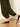 Someone wears the Sanctuary Clothing "the moment volume pant" in midnight moss, styled with black wedge sandals, walking on a light wooden floor against a plain off-white wall.