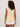 A woman with curly hair is seen from the back, wearing Sanctuary Clothing's So Twisted Muscle Tee in Banana, paired with white shorts against a plain light background.