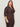 A woman with long brown hair wears the Sanctuary Clothing textured knit Dreamgirl Top in Semi Sweet, featuring long sleeves and extended sizing, paired with matching pants, standing against a light background and looking to the side.