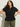 A woman with curly dark hair models the Sanctuary Clothing lace up timeless tee in black (extended sizing), paired with olive green cargo pants. She stands confidently with her hands on her hips against a plain light background.