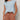 A woman wears the Sanctuary Clothing easy sweater tee in blue aura (petite sizing), tucked into high-waisted, rolled brown shorts with a dark brown belt, standing against a plain light background.