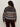 A person with long curly hair is seen from the back, wearing Sanctuary Clothing„¢s zip up fairisle hoodie mocha fairisle extended sizing and dark pants.