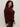 A woman with curly dark hair models the Sanctuary Clothing boucle cardi in dark crimson (extended sizing), paired with dark jeans, standing against a plain light background and looking neutrally at the camera.