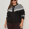 A woman wearing Sanctuary Clothingžs fairisle crewneck cardi ink multi (extended sizing), featuring white and black Fair Isle patterns, stands confidently against a light background, sunglasses on and hands by her sides.