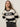 A woman with long brown hair wears Sanctuary Clothing„¢s 24 7 Popover Black with Chalk Stripe sweater. She stands against a light background, looking to the side with a neutral expression.