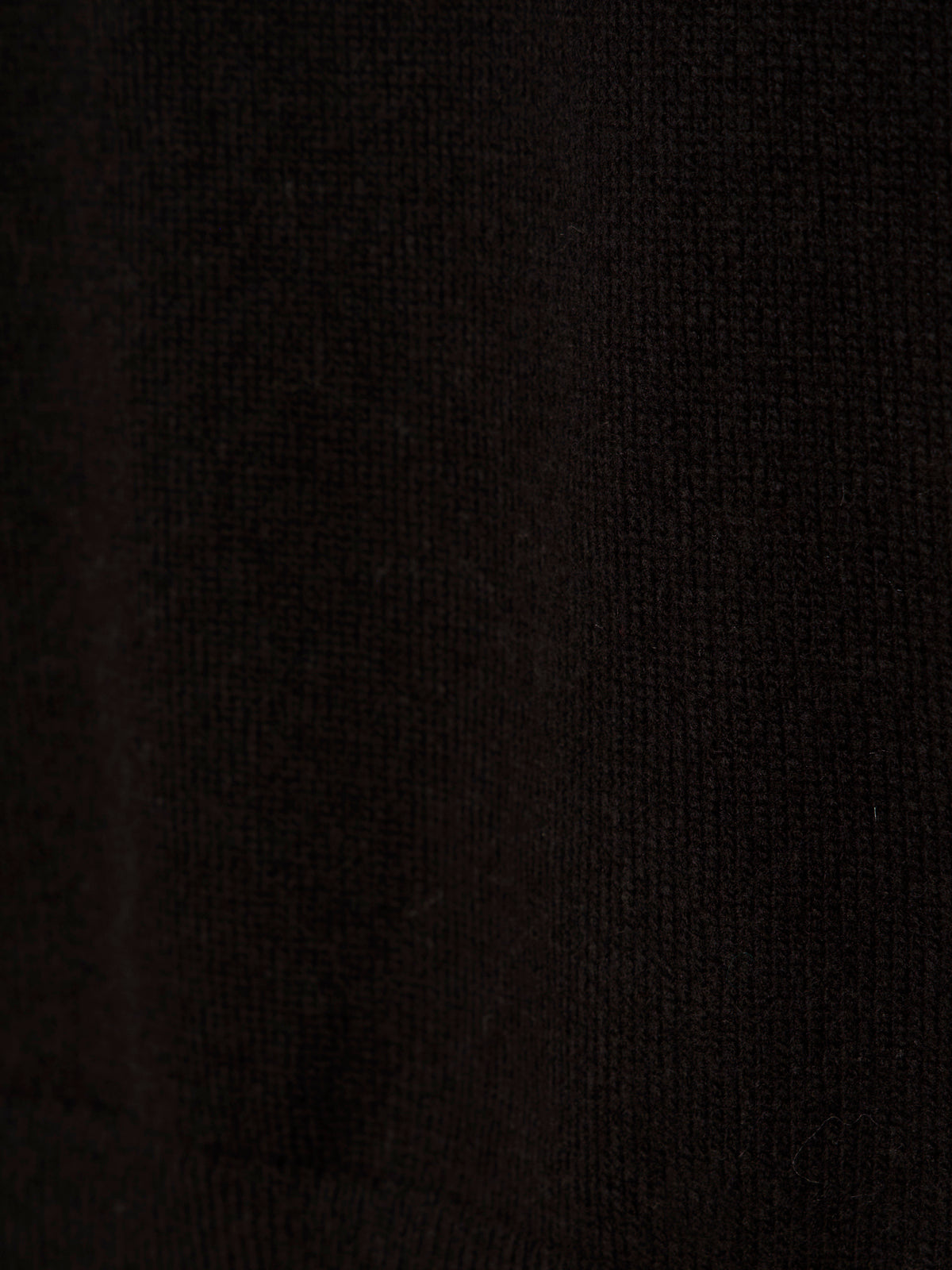 Close-up of the easy layering shell black by Sanctuary Clothing, featuring textured black fabric with fine knit patterns and subtle shading variations.