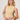 A woman with blonde hair wears the Sanctuary Clothing "in the mix sweater tank banana" and cream pants, accessorized with chunky bracelets, as she poses against a light wall looking slightly to the side with a relaxed expression.