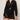 A woman wears the Sanctuary Clothing laguna openwork bomber in black (petite sizing) with a matching mini skirt, both featuring a sheer crochet knit. She has wavy blonde hair and accessorizes with a bangle bracelet.