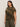 A woman with long dark hair models Sanctuary Clothing’s “the perfect tee hiker camo” from the inclusive collection, pairing the short-sleeve green and brown camouflage t-shirt with olive green pants against a plain light background.